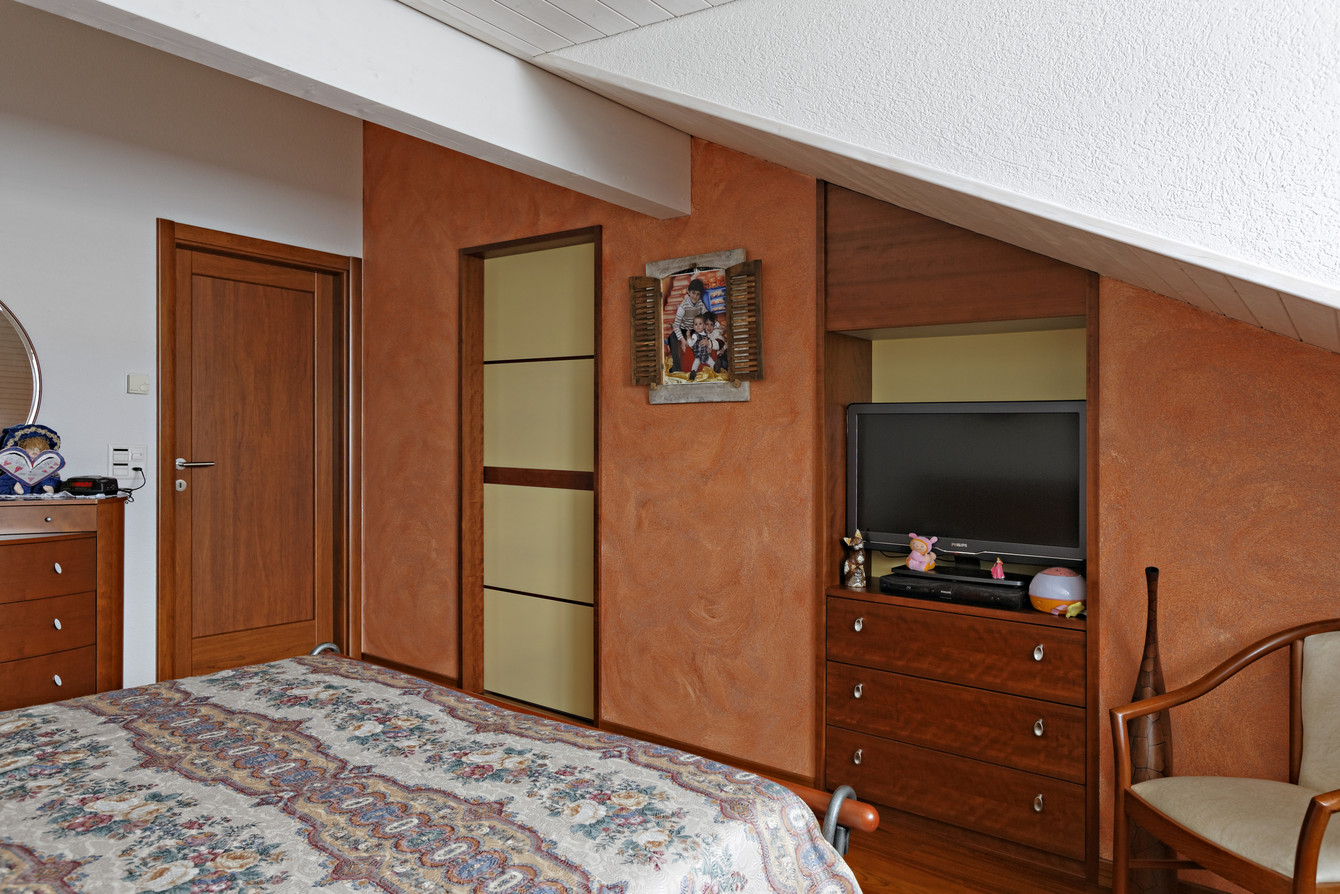 Südländisches Flair im Schlafzimmer mit passender Schiebetüre in die begehbare Ankleide mit Holzrahmenprofilen und Glas 