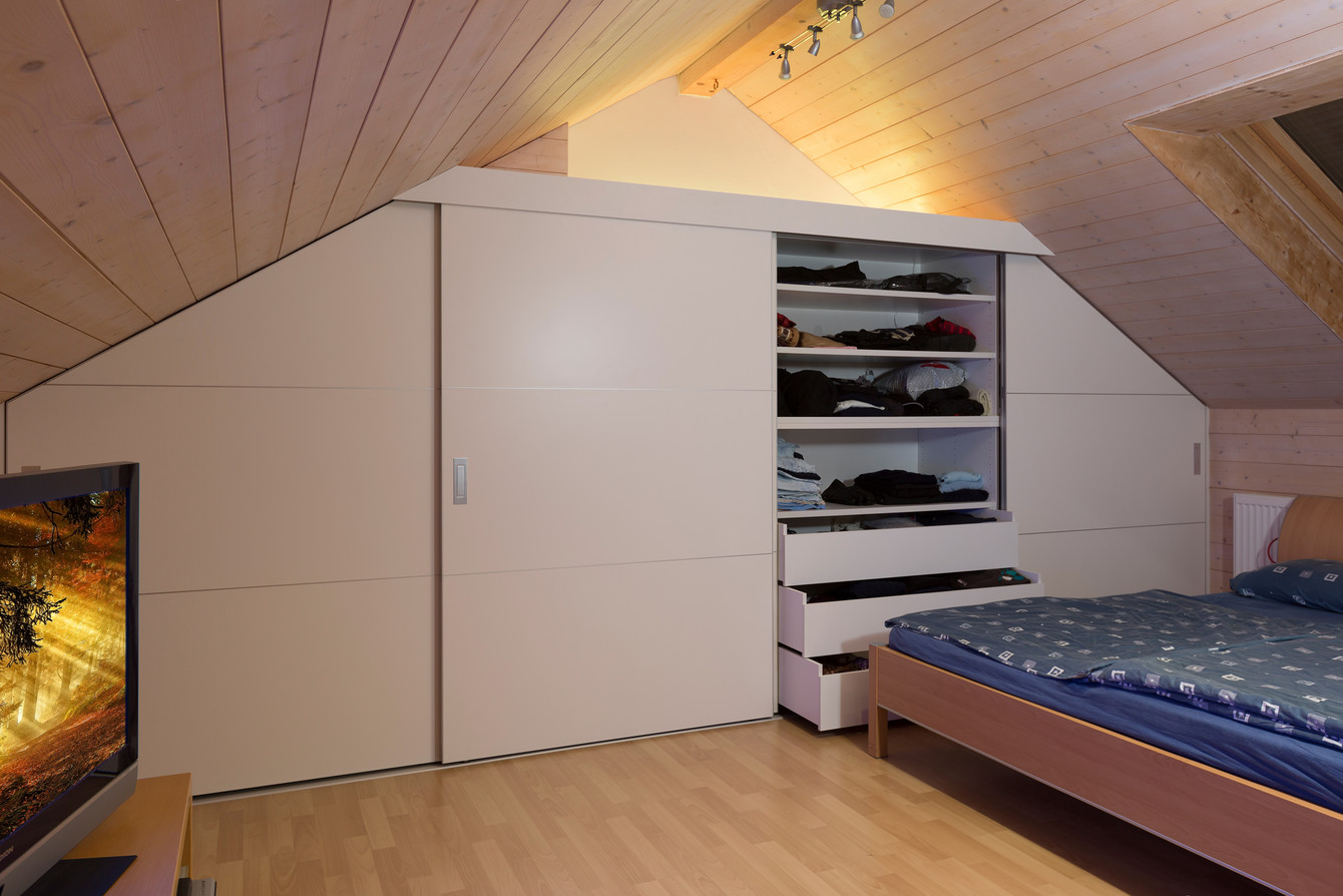 Schlafzimmerschrank unter dem Dachstock mit zwei schräg und zwei gerade gefertigten Schiebetüren 