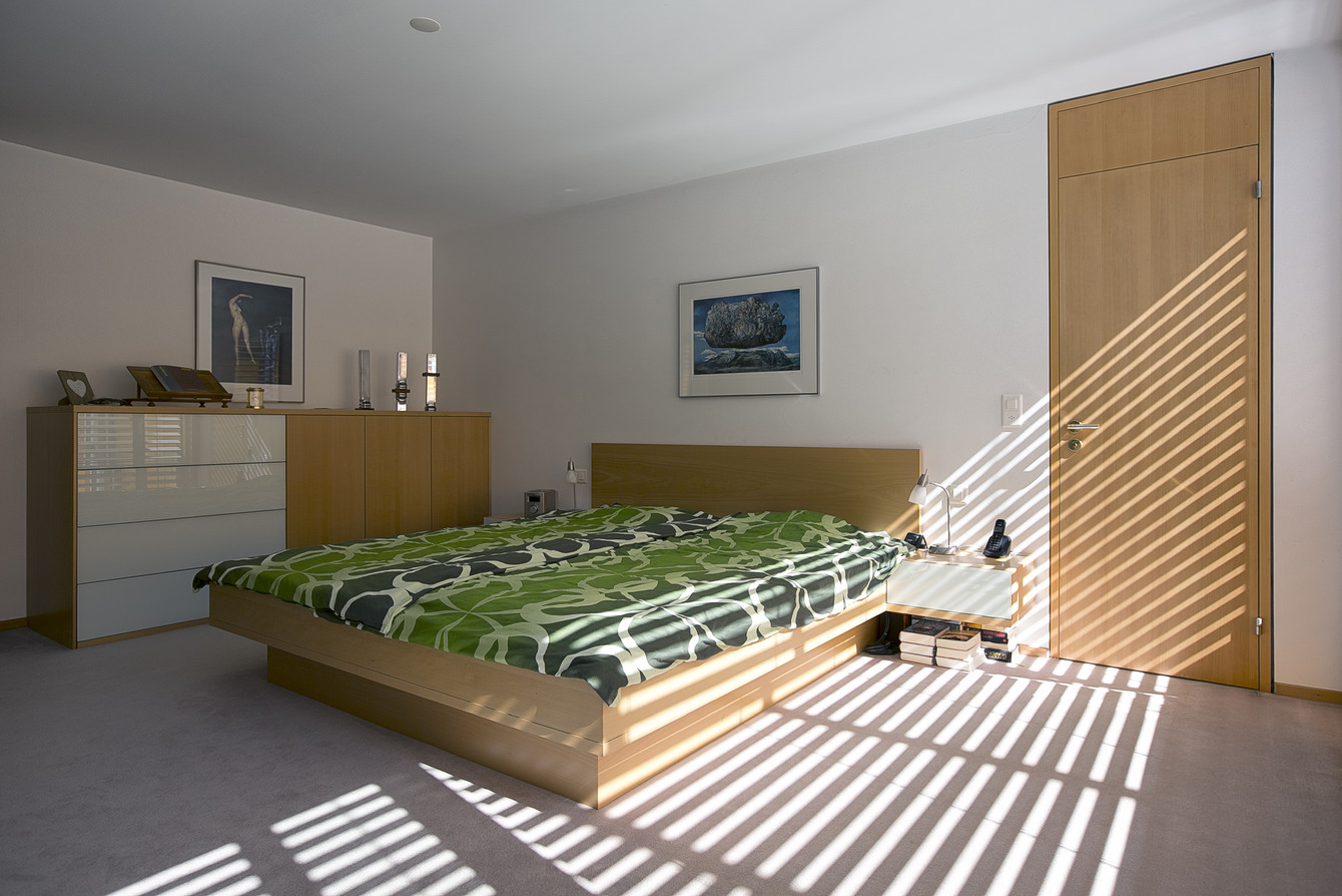 Abendliches Sonnenspiel im heimeligen Schlafzimmer mit Doppelbett und Kommode