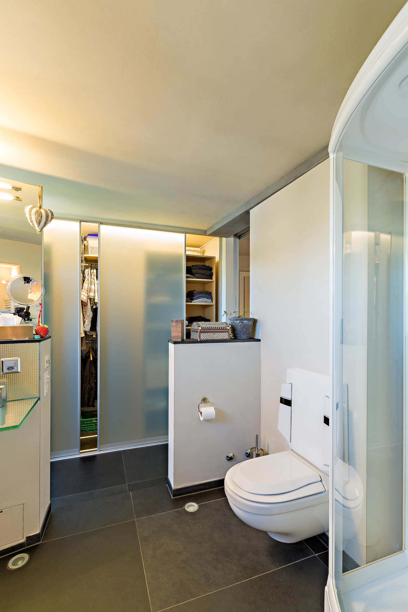 Viel Stauraum bietet ein Schiebetürschrank im Badezimmer, hier als Kleiderschrank konzipiert