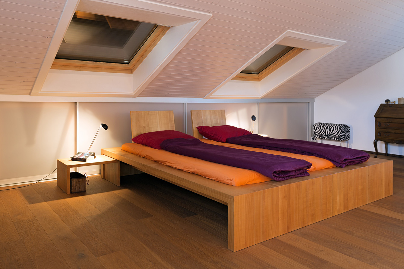 Dachschrägenverbau mit Schiebetüren hinter dem Bett macht Sinn für zusätzlichen Stauraum 
