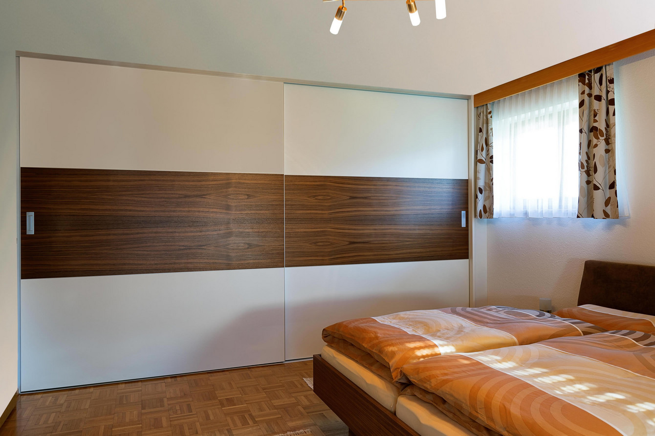 Schiebetürenschrank im Schlafzimmer im Materialwechsel Dekor - Holz - Dekor