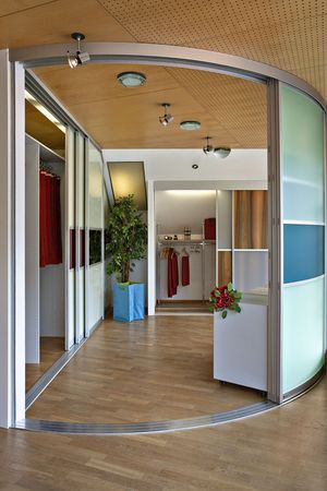 Raumteiler in gebogenem Acrylglas mit aufgesetzten Quersprossen in Alu