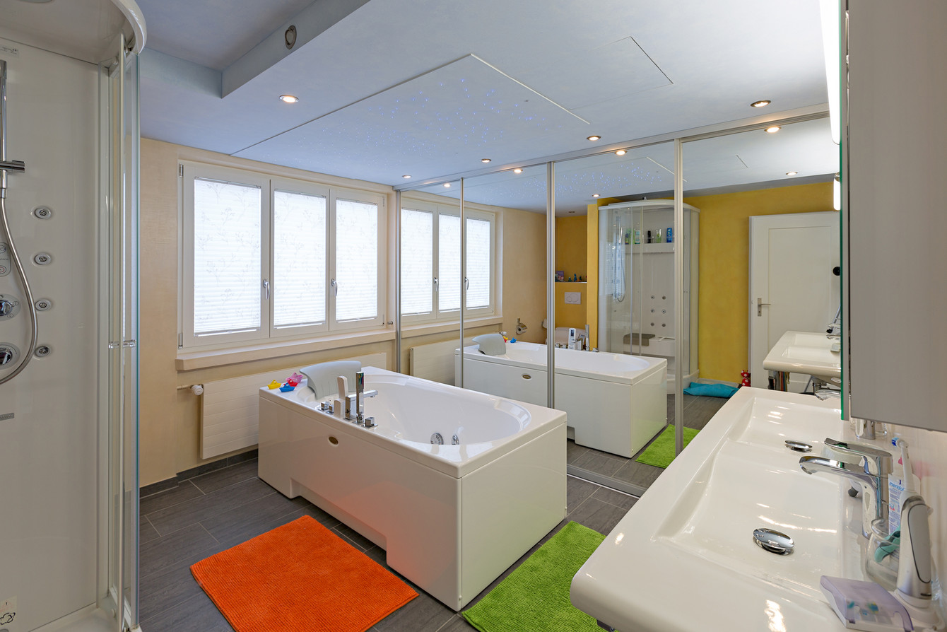 Schiebetüren mit raumhoher Spiegelfüllung mit Aluprofilen und dekorativer Spotbeleuchtung im Badezimmer 