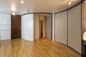 Gebogene Schiebetüre - raumhoch - als Abtrennung zwischen Räumen in hochglänzendem Acrylglas 