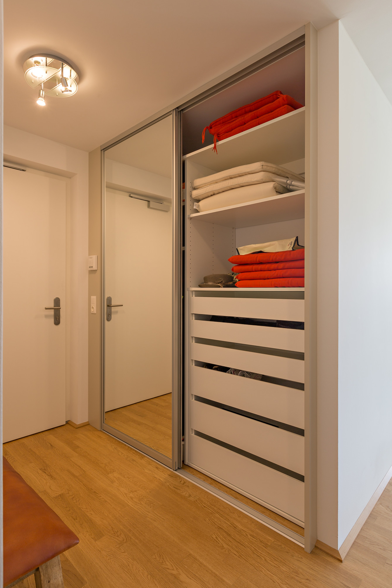 Garderobe mit eingebauten Schubladen mit offenem Griffschlitz, Tablaren und Kleiderstangen - Front in Spiegel und Dekor 