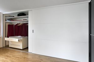 Überbreite Schiebetüren als Schrankfront rahmenlos in Schleiflack weiss mit hauchfeinen Sprossen und Muschelgriff