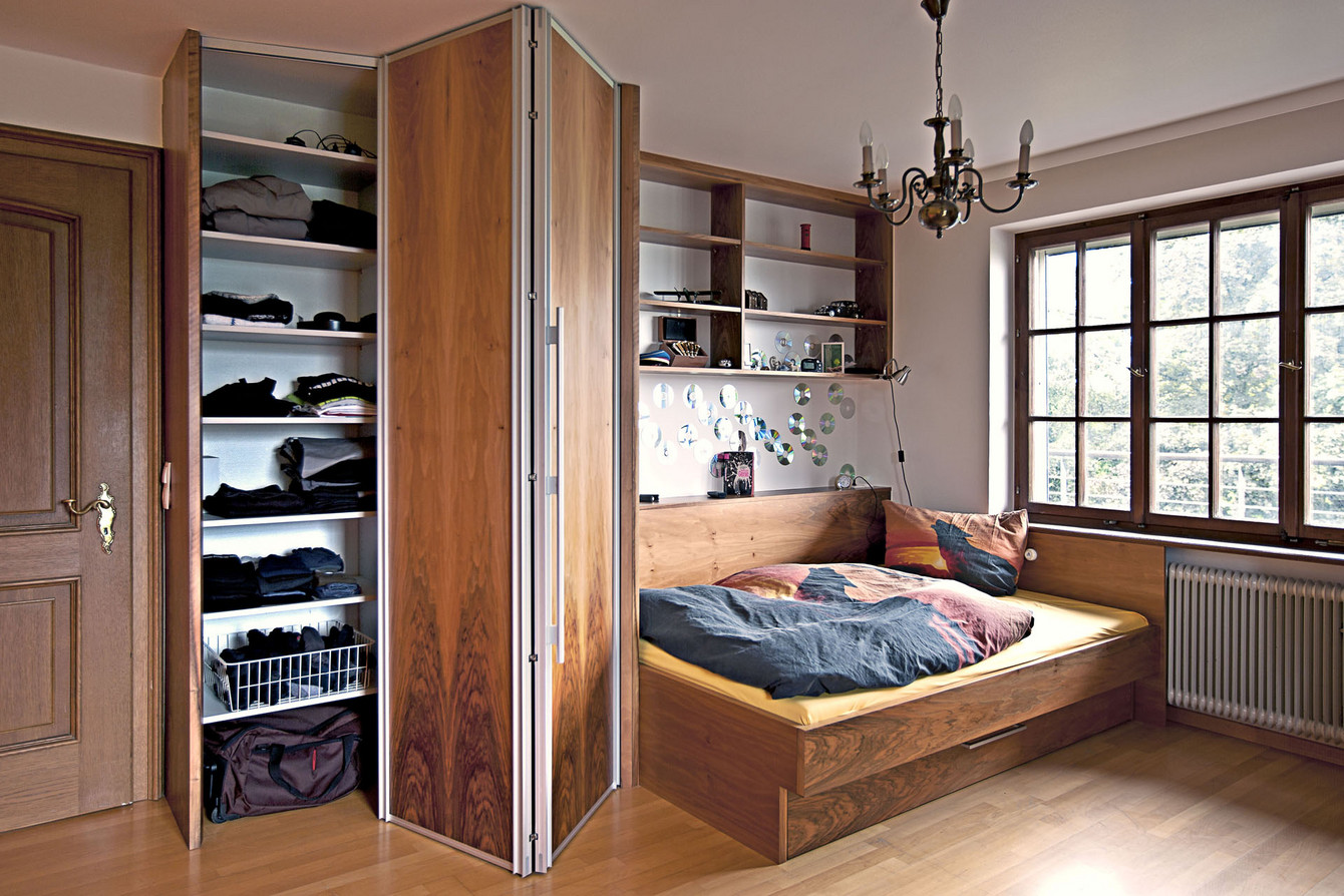 Bett in Nussholz mit angrenzendem Kleiderschrank mit Falttüren
