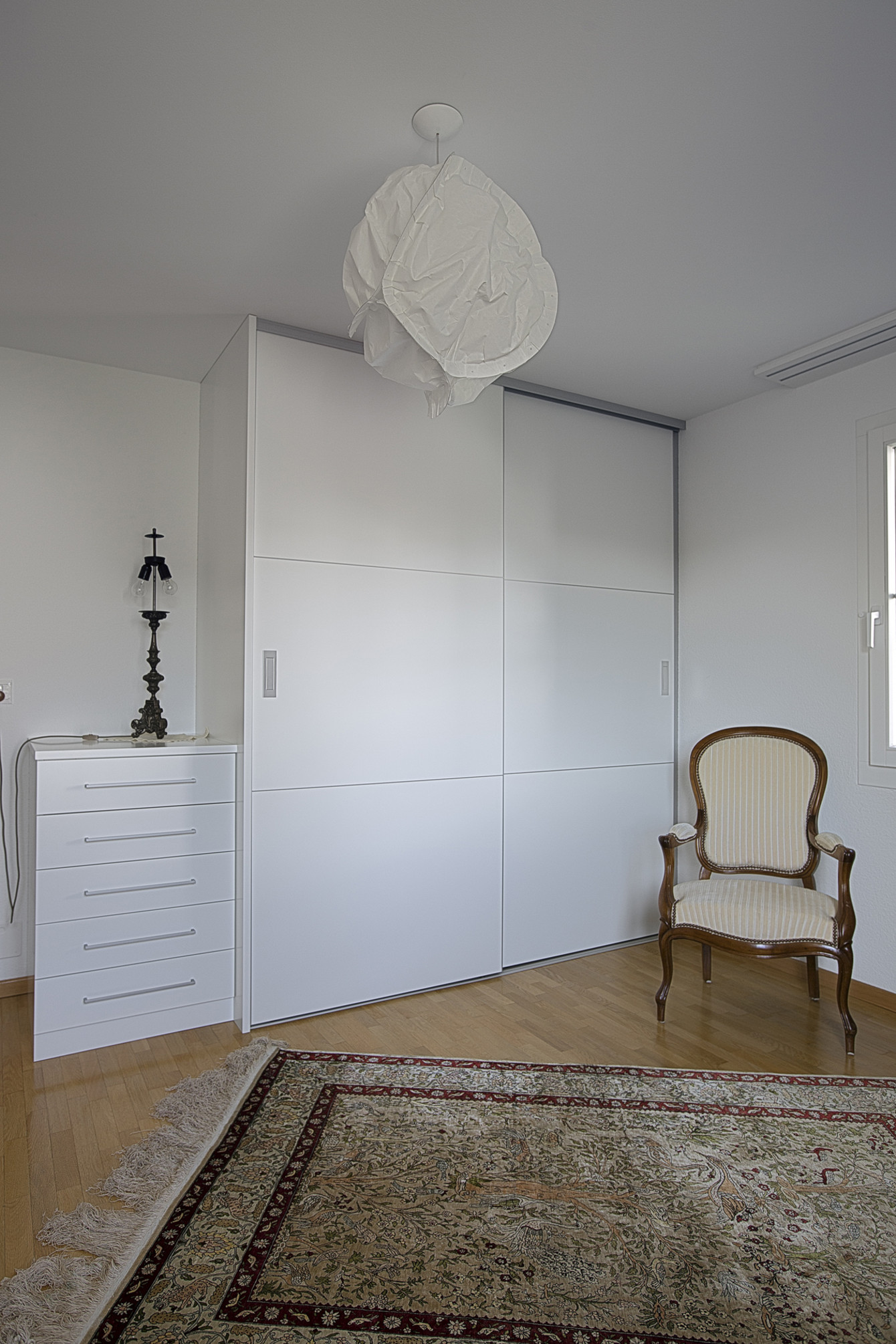 Rahmenloser Einbauschrank im Arbeitszimmer mit separatem Schubladenmöbel in strahlendem Weiss gehalten 